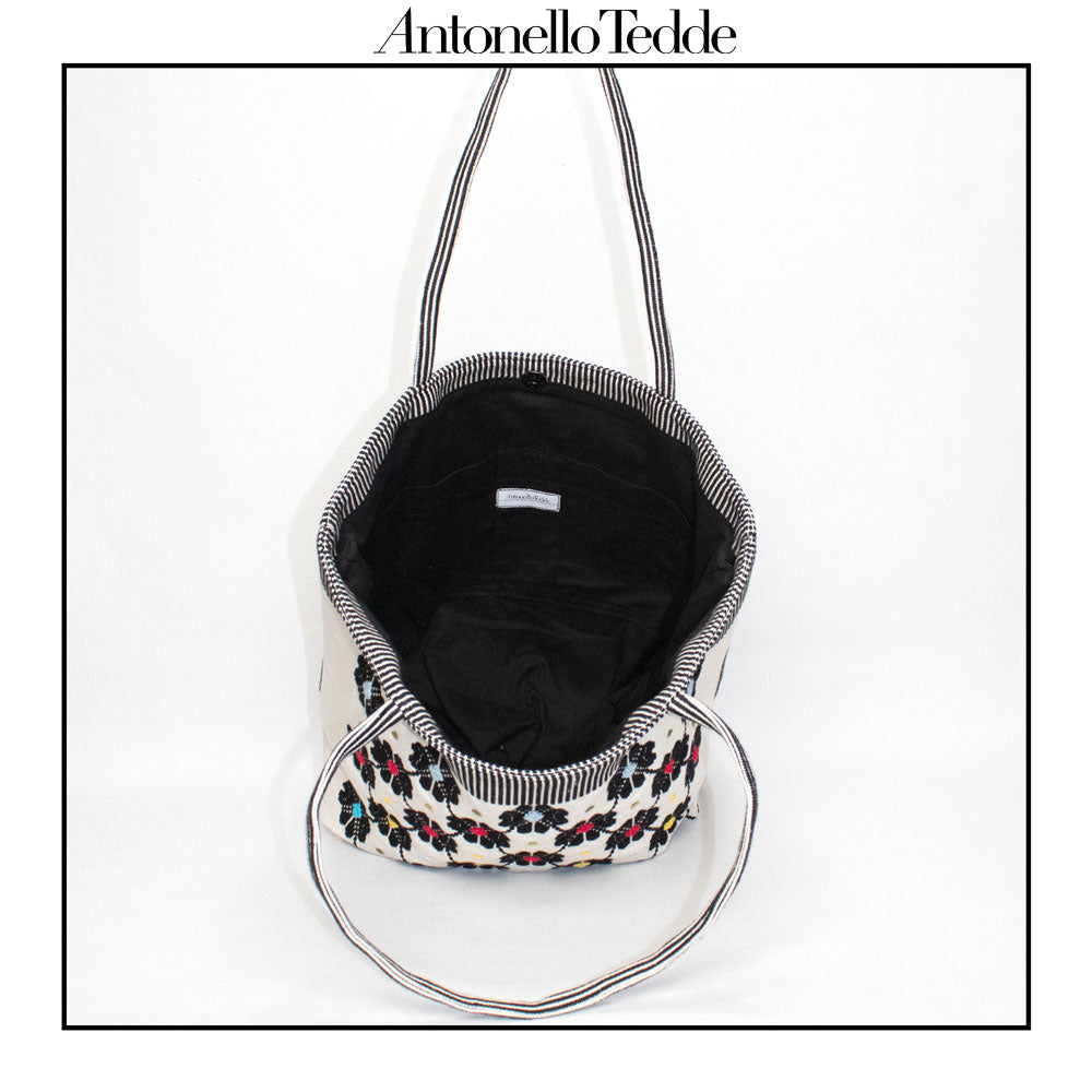 Inside view of a black and white tote bag with a daisies pattern. Main view of our Sustainable tote - summer bag - luxury handbag - handwoven made in Italy by hand - timeless individualistic fashion • eco-friendly fashion • socially responsible, lasting fashion.