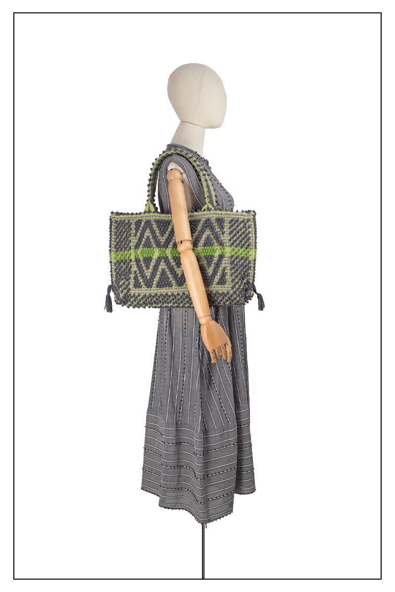 Front view on model for proportions of the Capriccioli Tote Grey by Antonello Tedde, showcasing the grey hand-woven fabric with a vibrant green stripe and multiple diamonds pattern