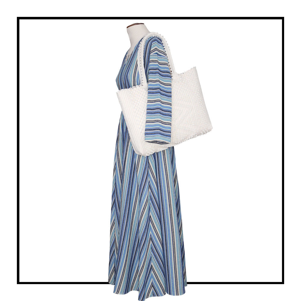 The handbag on a model is a cream linen Sustainable tote - summer bag - luxury handbag - handwoven black and white tote made in Italy by hand • timeless individualistic fashion • eco-friendly fashion • socially responsible, lasting fashion