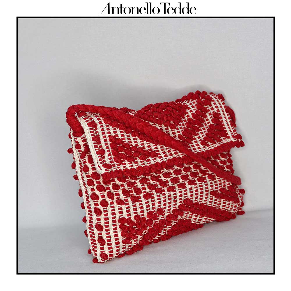 Side view of the Red and Cream ground beloved style within the Antonello Tedde collection, the Suni Rombi Clutch cross-body. The bag is celebrated for its effortless blend of elegance, function, and sustainable craftsmanship.
