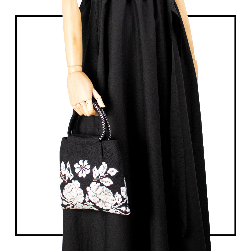 on model with black dress the black and white evening bag to complete your look with our selection of accessories crafted with the environment in mind