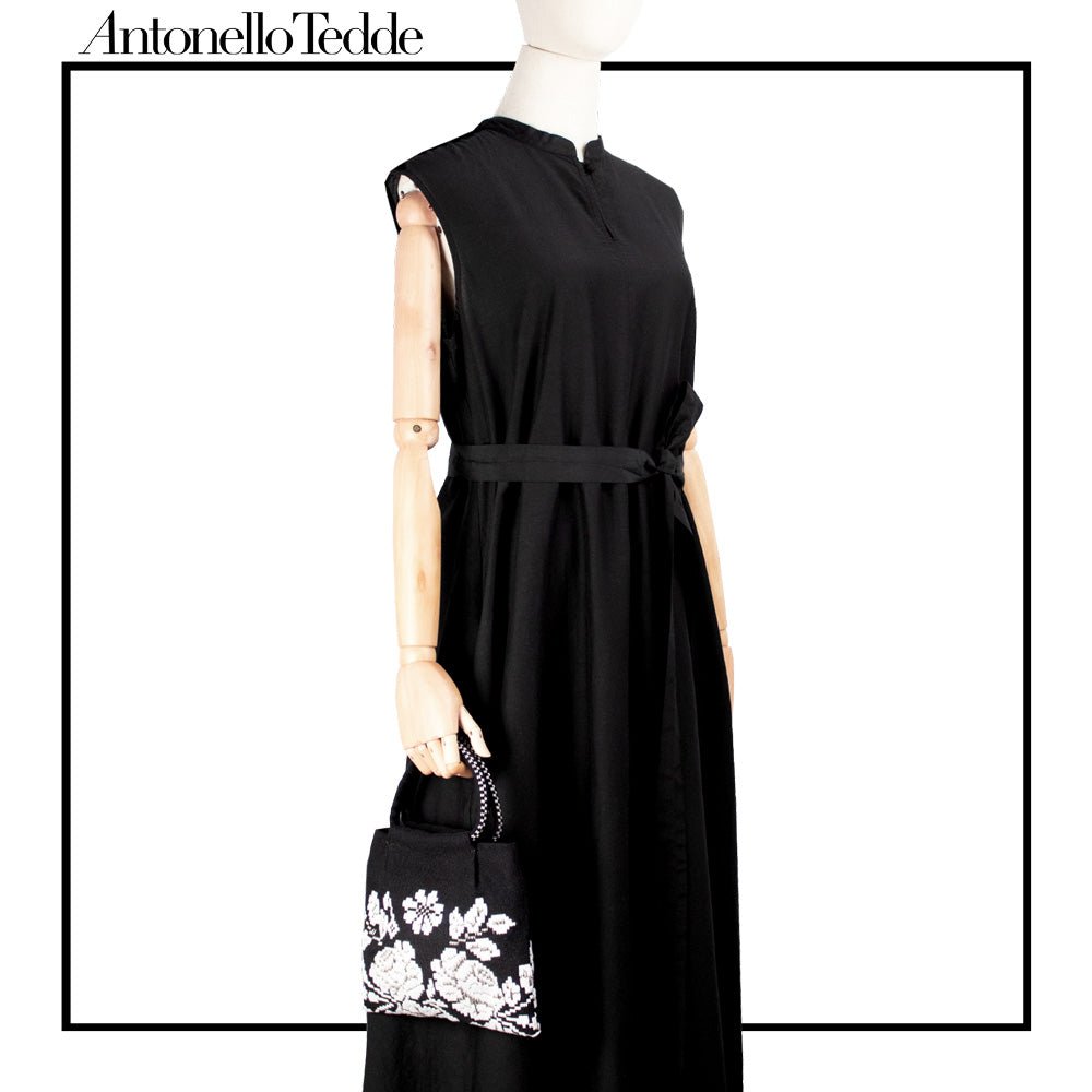 Mini woven clutch with contrasting flower pattern with metallic detail, ideal for evening or special events.