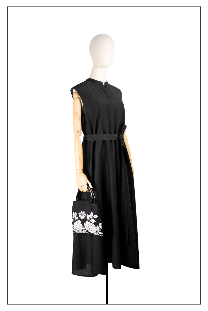 On model view for proportions of the black and white evening bag to complete your look with our selection of accessories crafted with the environment in mind