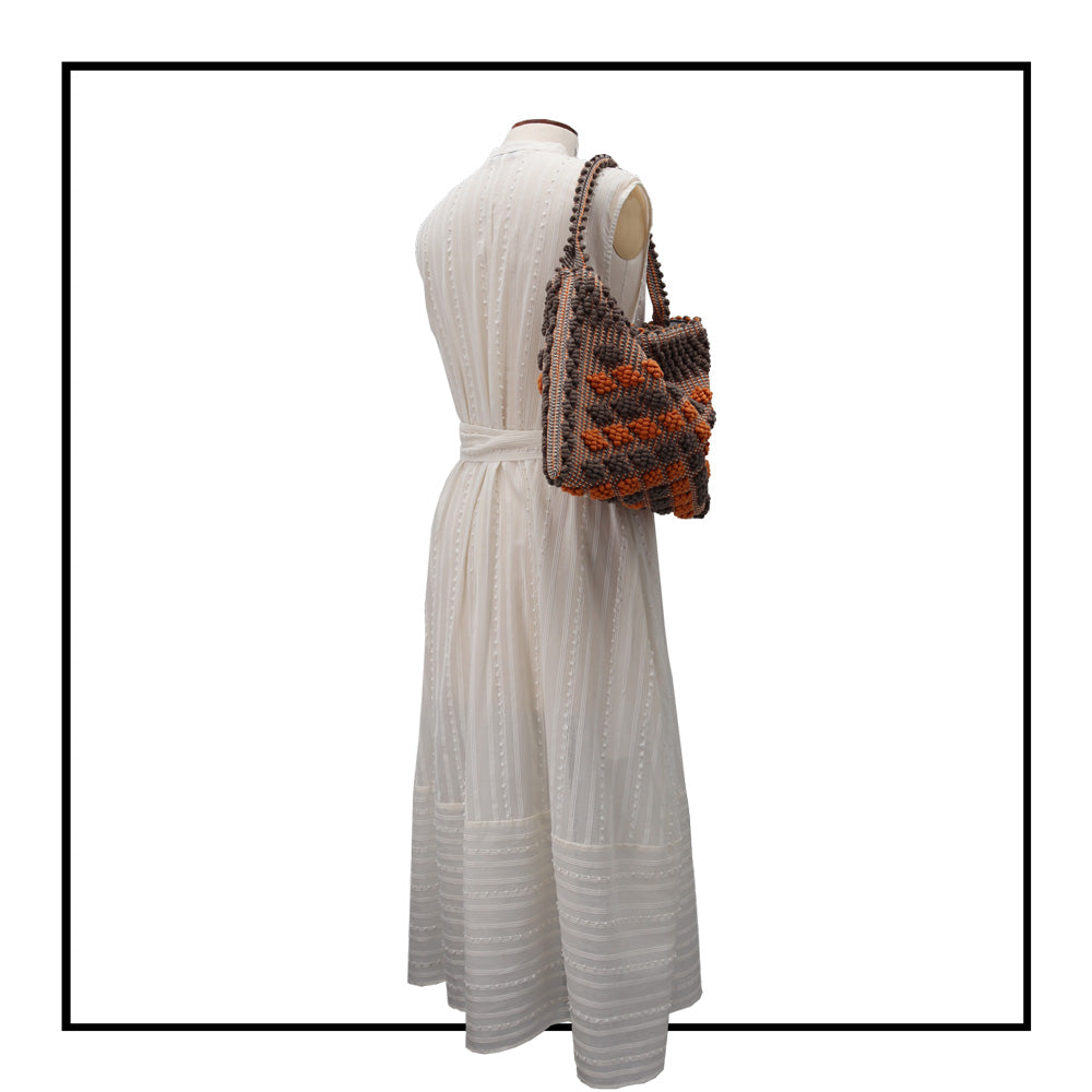 Full length On stand, side size 12 view of Quality eco-conscious hobo bag handwoven orange and taupe. Stylish clothes and Eco-Friendly with recycled yarns #luxury #ecoconcious #sustainablestyle  #ethicalbrands #ecoliving  #ecofashion #ecostyle #ethicalhandbags #handbags #sustainablelifestyle #ethicalfashion #sustainability