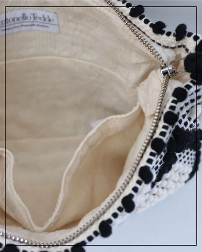 Antonello Tedde cream and white  clutch bag with multiple diamond patterns and pom-pom details on a white background - opening view