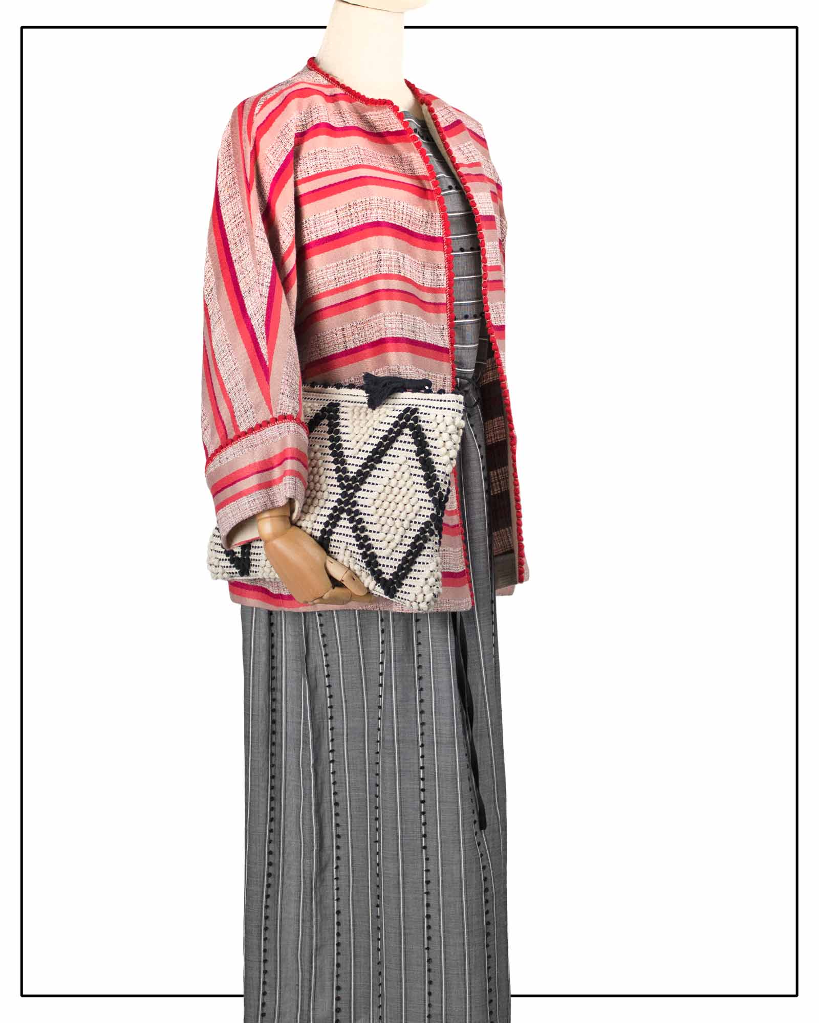 Mannequin wearing an Antonello Tedde red-and-white striped jacket with a black-and-white patterned bag. 