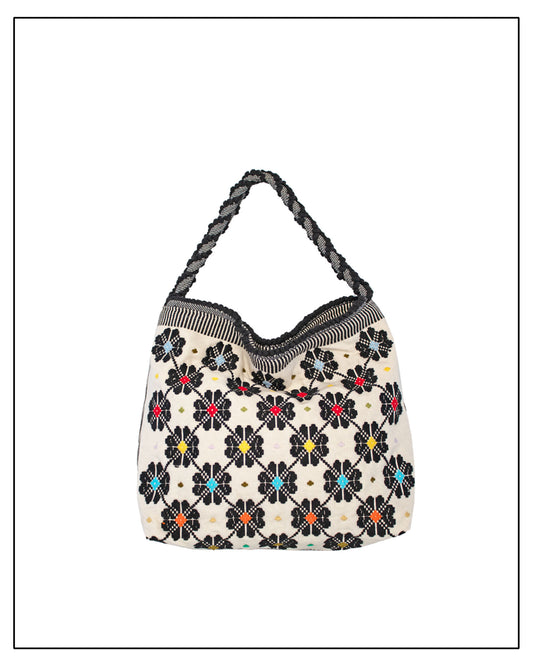 Floral-patterned bag with a black handle on a white background