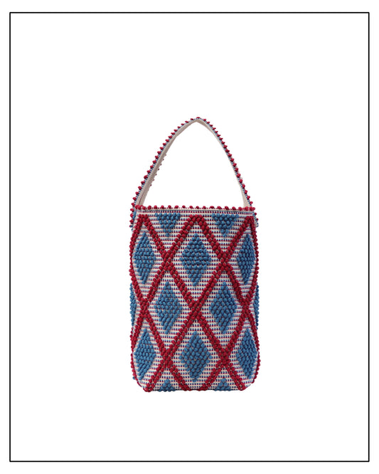 An Antonello Tedde woven bucket bag with a red-and-blue geometric diamond pattern, featuring a single shoulder strap, shown against a plain white background.