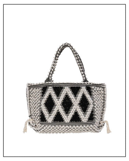 Woven handbag with a black geometric pattern on a white background.  Antonello Tedde's luxury eco-conscious fashion. 