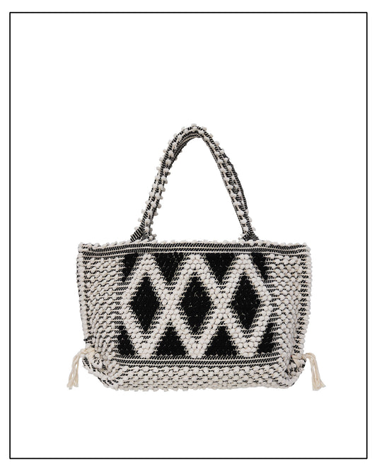 Woven handbag with a black geometric pattern on a white background.  Antonello Tedde's luxury eco-conscious fashion. 