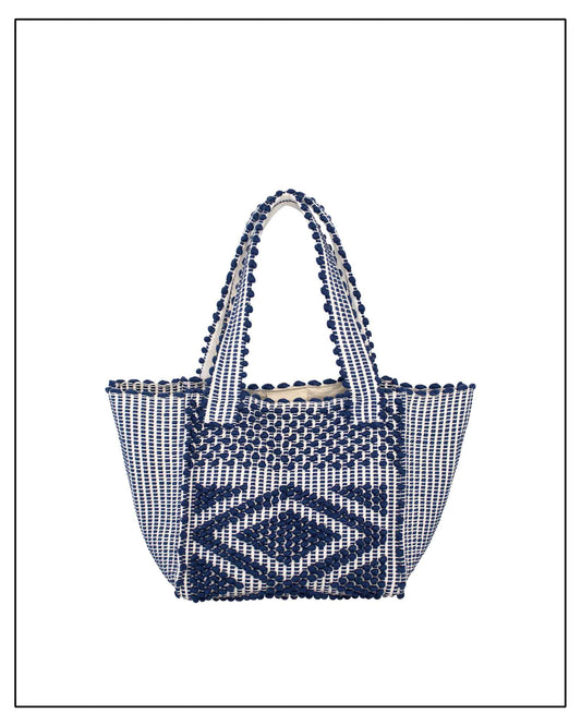 Antonello Tedde Pula Medium Tote Bag is handwoven in Sardinia with blue and white  background yarn, a diamond pattern, and a practical flap pocket. 