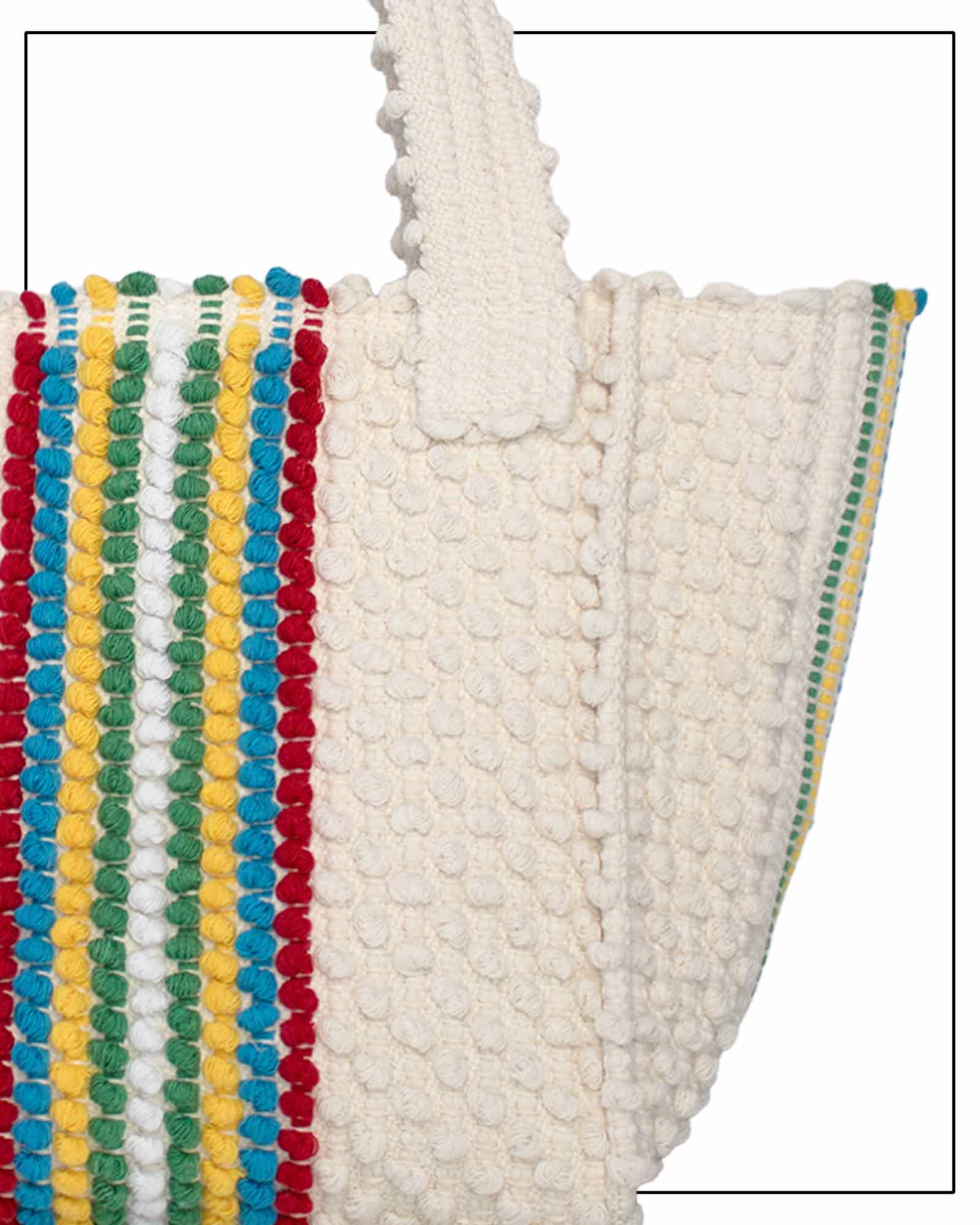 Textile with colourful pom-pom trim on a white background - Pula Medium Tote Bag, a reimagined classic that marks the return of the beloved striscie (stripes) pattern in a fresh, contemporary silhouette.