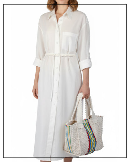 Person wearing a white dress holding a colourful hand-woven bag on a white background from ANTONELLO TEDDE 