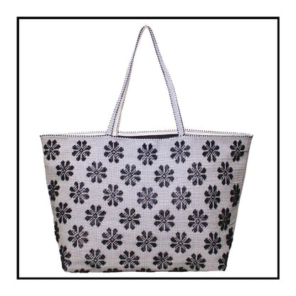Front view of a black and white tote bag with a daisies pattern. Main view of our Sustainable tote - summer bag - luxury handbag - handwoven made in Italy by hand  - timeless individualistic fashion • eco-friendly fashion • socially responsible, lasting fashion.