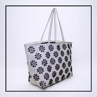 Side view of a black and white tote bag with a daisies pattern. Main view of our Sustainable tote - summer bag - luxury handbag - handwoven made in Italy by hand  - timeless individualistic fashion • eco-friendly fashion • socially responsible, lasting fashion.
