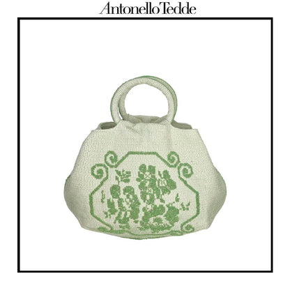 A handwoven green Faona tote bag with a small pibiones flower bouquet pattern and golden thread was crafted from regenerated cotton by Sardinian artisans.
