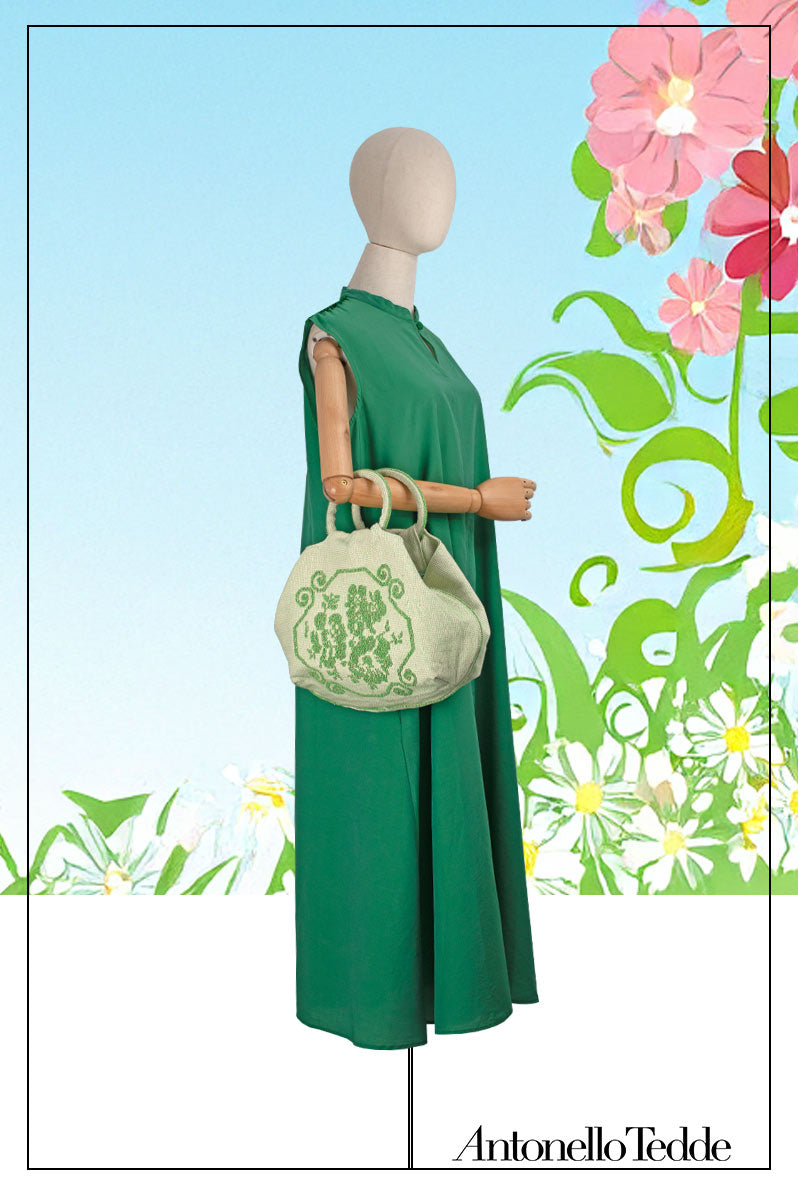 A handwoven green Faona tote bag with a small pibiones flower bouquet pattern and golden thread was crafted from regenerated cotton by Sardinian artisans.