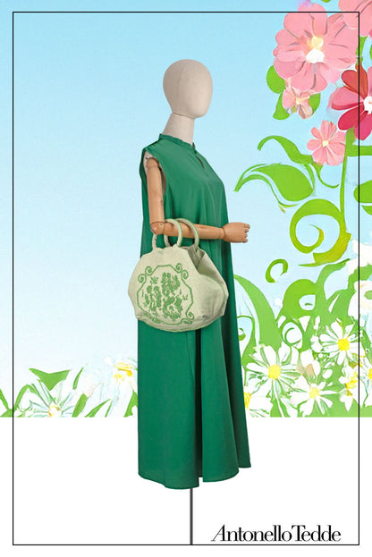 A handwoven green Faona tote bag with a small pibiones flower bouquet pattern and golden thread was crafted from regenerated cotton by Sardinian artisans.