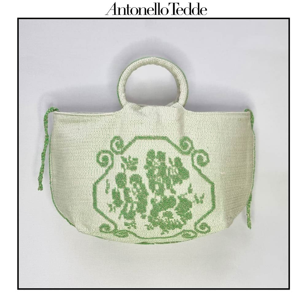 Front view of the  handwoven green Faona tote bag with a small pibiones flower bouquet pattern and golden thread was crafted from regenerated cotton by Sardinian artisans.