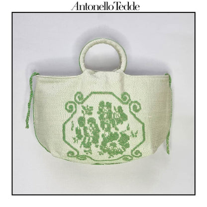 Front view of the  handwoven green Faona tote bag with a small pibiones flower bouquet pattern and golden thread was crafted from regenerated cotton by Sardinian artisans.