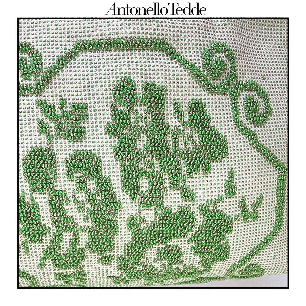 Detail view of the handwoven green Faona tote bag with a small pibiones flower bouquet pattern and golden thread was crafted from regenerated cotton by Sardinian artisans.