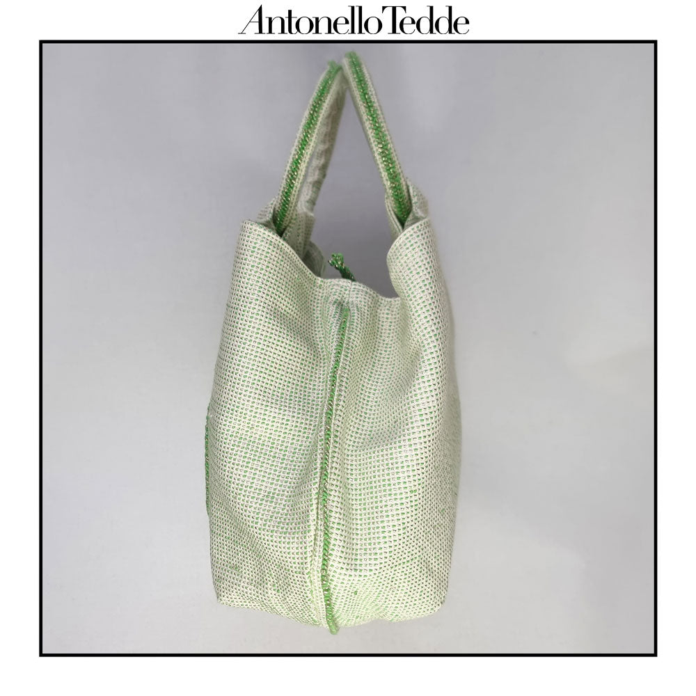 Side view of the handwoven green Faona tote bag with a small pibiones flower bouquet pattern and golden thread was crafted from regenerated cotton by Sardinian artisans.