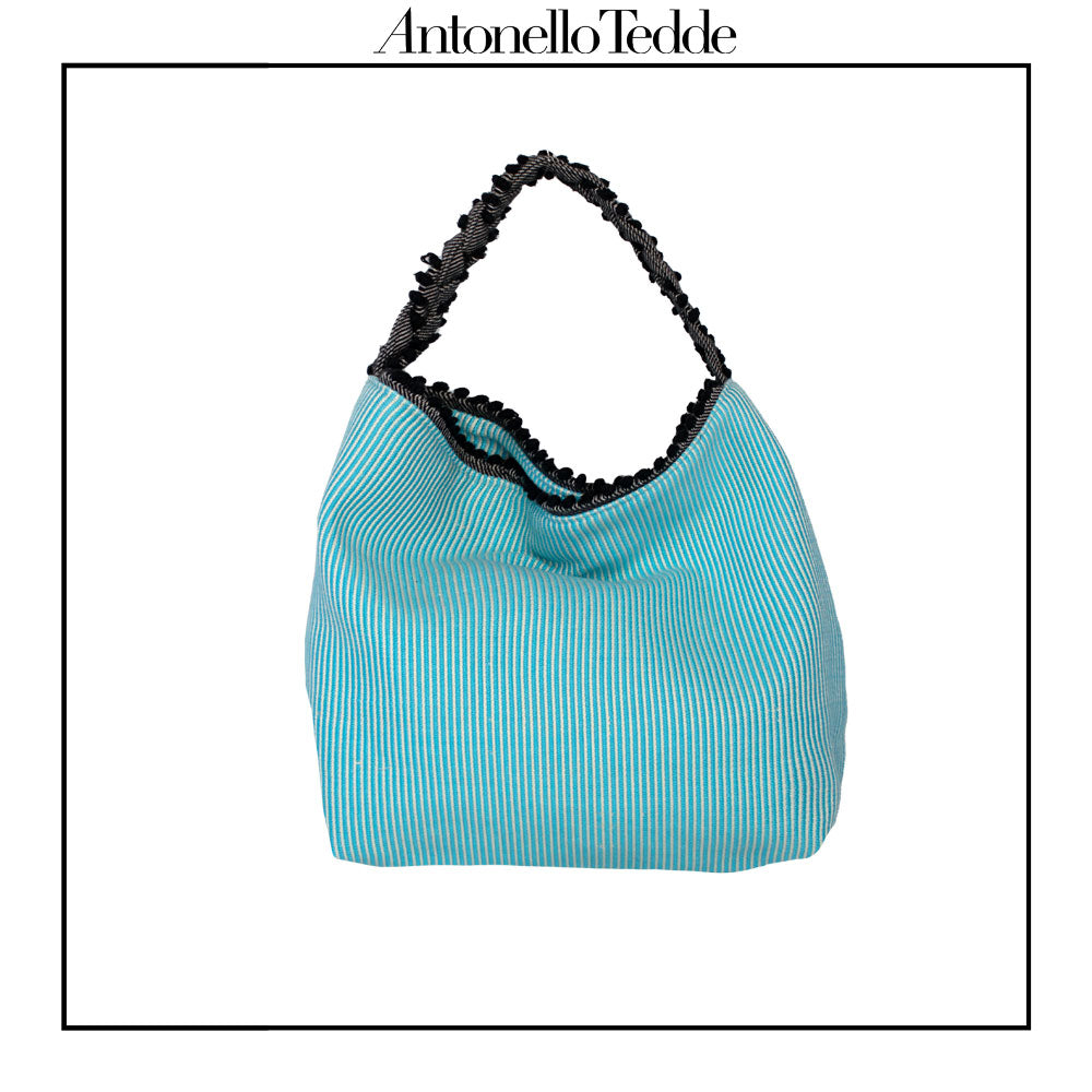 Back view of a turquoise, black and white tote bag with a daisy pattern. Main view of our Sustainable tote - summer bag - luxury handbag - handwoven made in Italy by hand  - timeless individualistic fashion • eco-friendly fashion • socially responsible, lasting fashion.