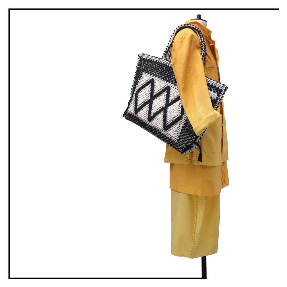 The handbag on a model - Sustainable tote - summer bag - luxury handbag - handwoven black and white tote made in Italy by hand • timeless individualistic fashion • eco-friendly fashion • socially responsible, lasting fashion.