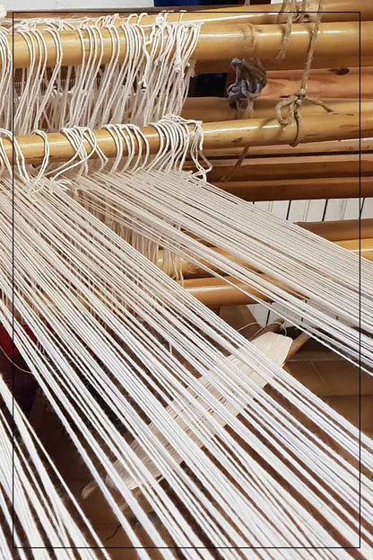 Close-up of a loom with threads and wooden beams where ANTONELLO TEDDE fabrics are made 