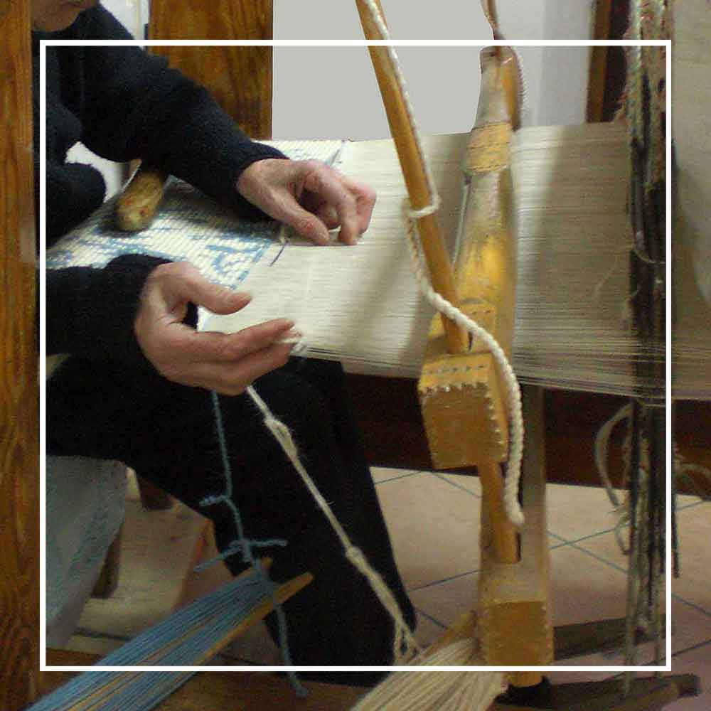 expert weaver on traditional wooden loom where the handbags are made - Sustainable tote - summer bag - luxury handbag - handwoven black and white tote made in Italy by hand • timeless individualistic fashion • eco-friendly fashion • socially responsible, lasting fashion