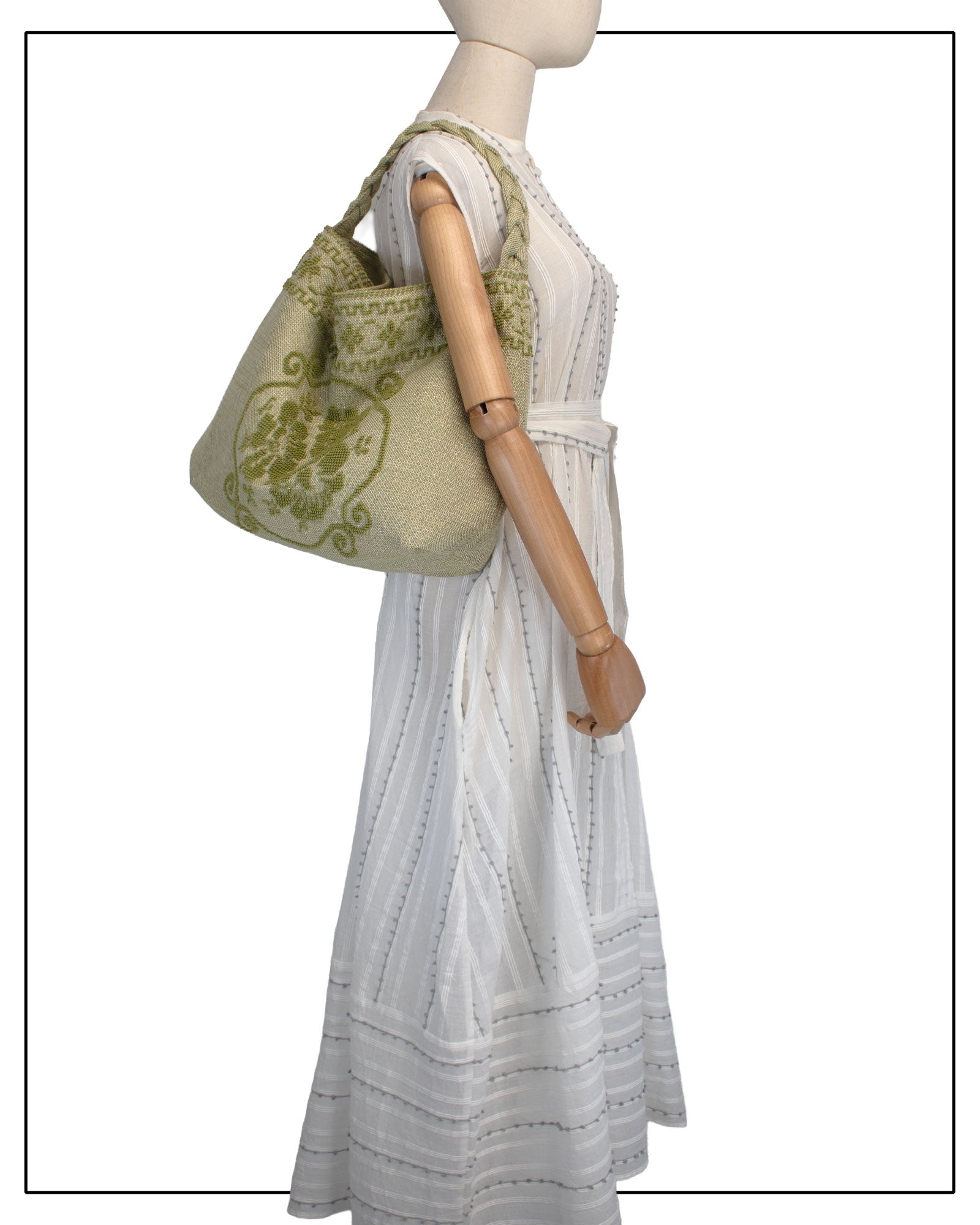 Antonello Tedde Banari Tote Bag handwoven in Sardinia using the traditional small Pibiones technique with green regenerated cotton, golden yarn, and floral bouquet motif. On the model view