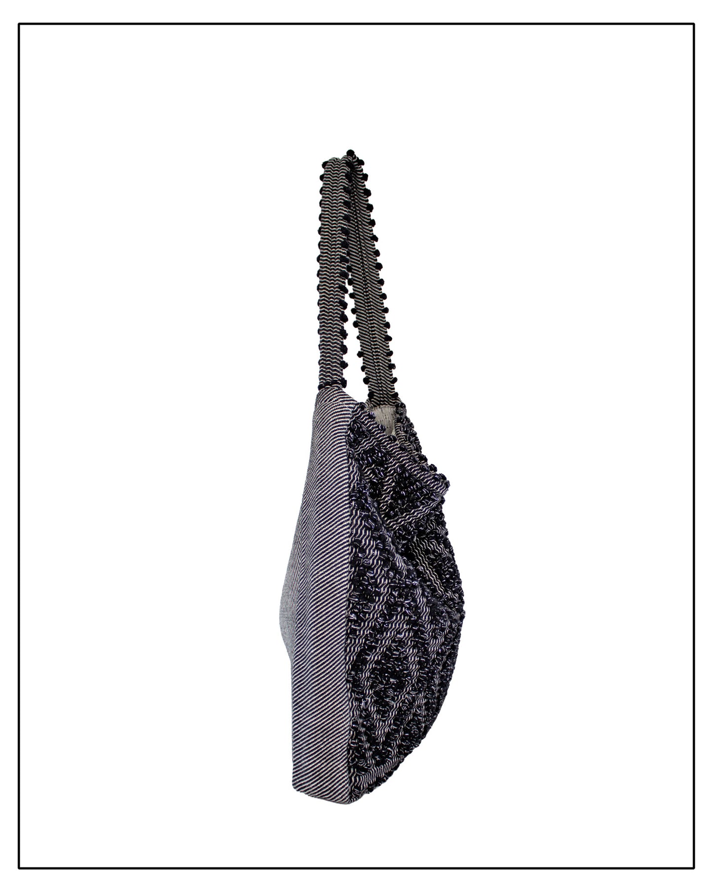 Side view of Antonello Tedde Bultei handwoven tote bag in black cotton with subtle silver highlights and textured woven front panel, handcrafted in Sardinia.