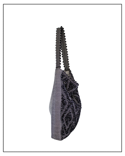 Side view of Antonello Tedde Bultei handwoven tote bag in black cotton with subtle silver highlights and textured woven front panel, handcrafted in Sardinia.