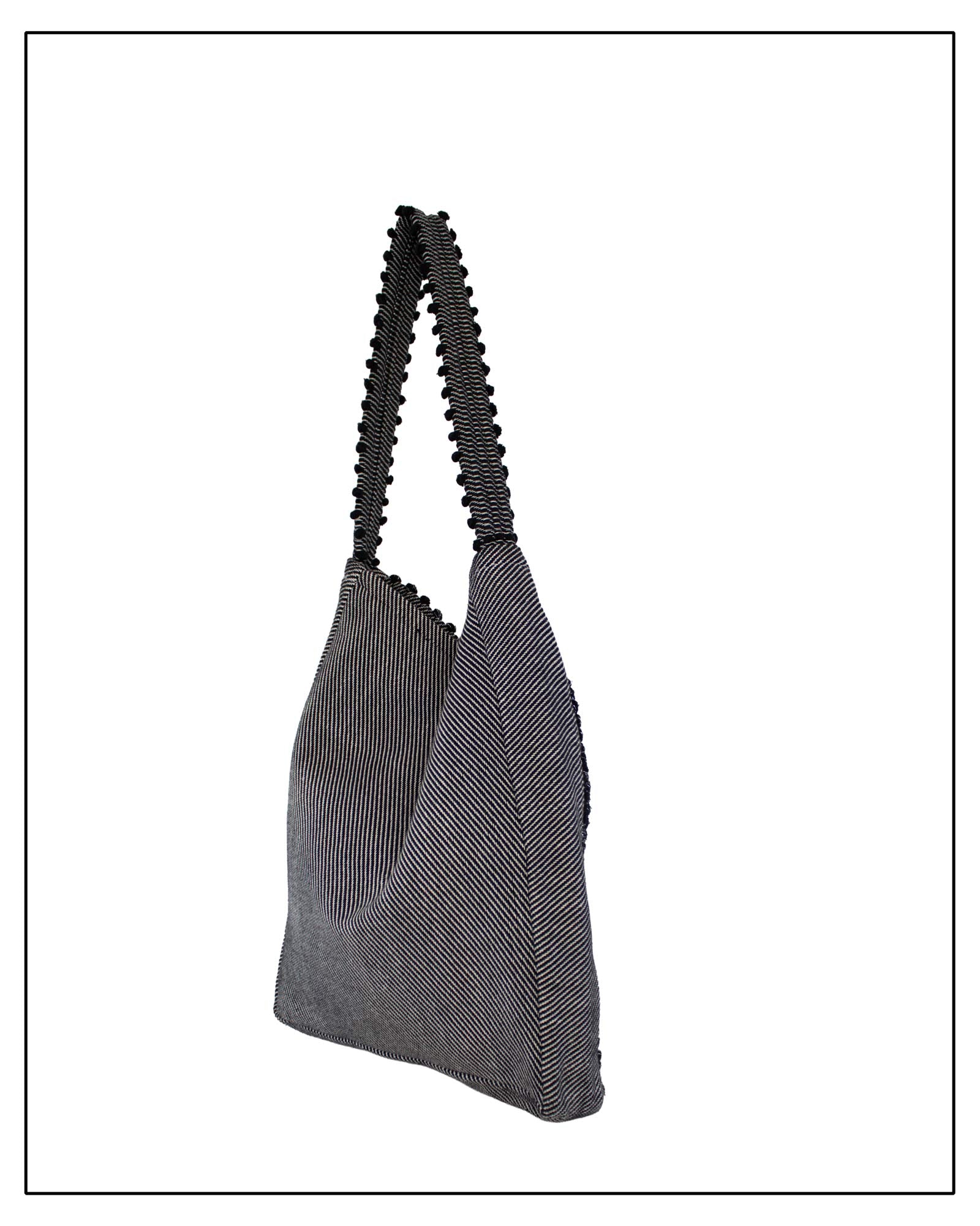 Side view of Antonello Tedde Bultei handwoven tote bag in black cotton with subtle silver highlights and textured woven front panel, handcrafted in Sardinia.