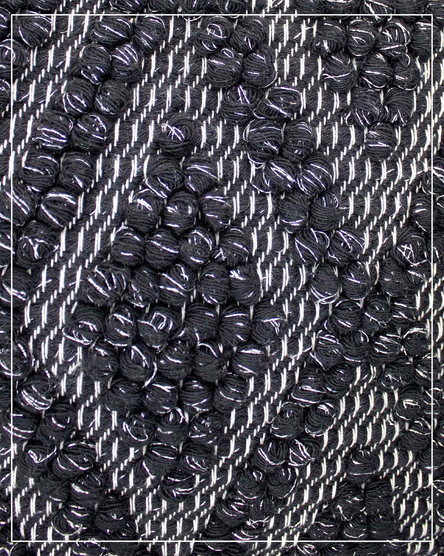 Fabric detail view of Antonello Tedde Bultei handwoven tote bag in black cotton with subtle silver highlights and textured woven front panel, handcrafted in Sardinia.