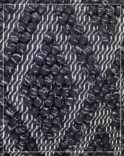 Fabric detail view of Antonello Tedde Bultei handwoven tote bag in black cotton with subtle silver highlights and textured woven front panel, handcrafted in Sardinia.