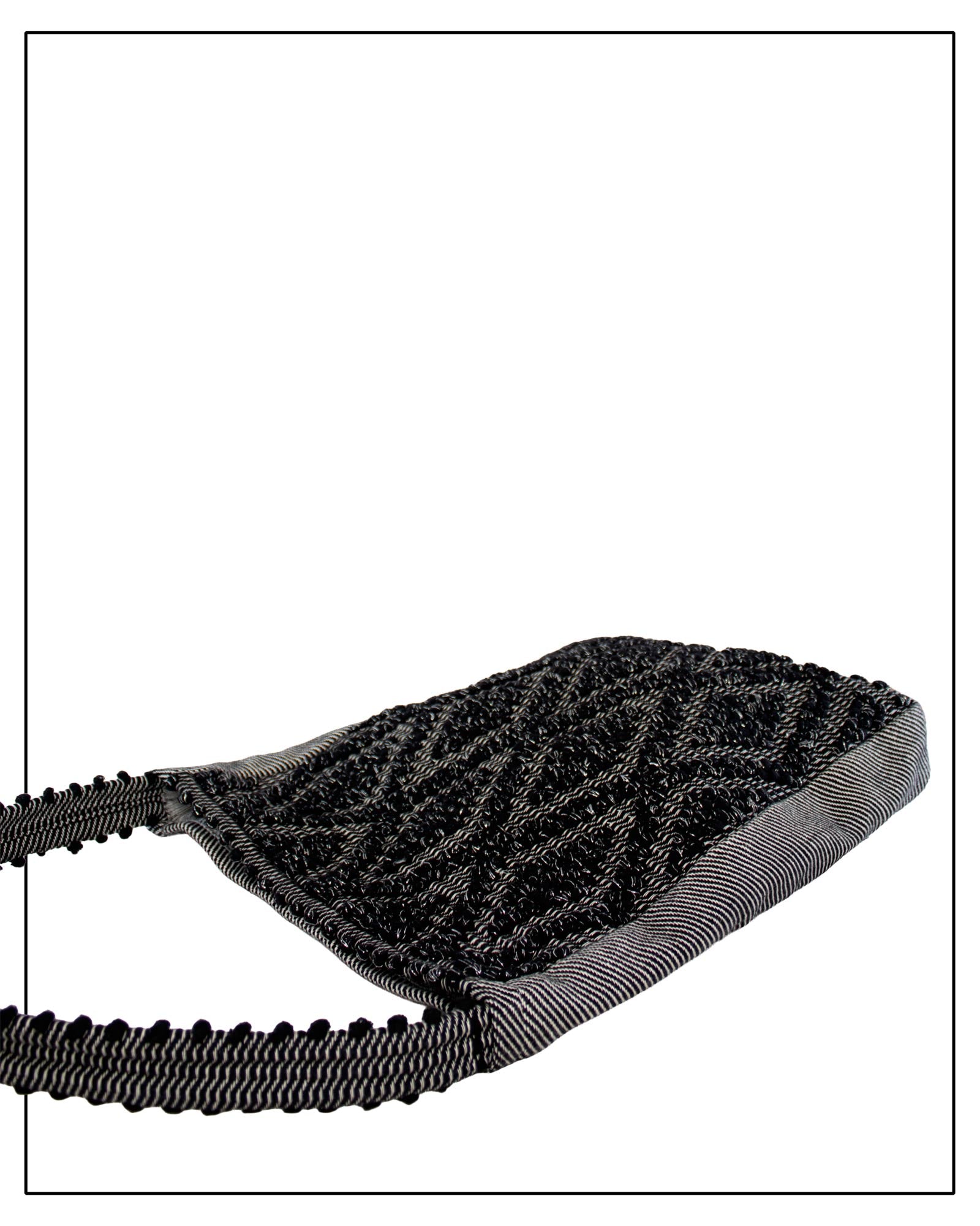 Flat view of Antonello Tedde Bultei handwoven tote bag in black cotton with subtle silver highlights and textured woven front panel, handcrafted in Sardinia.