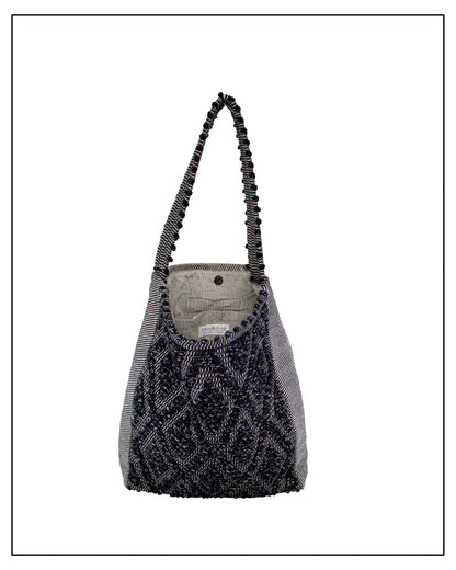 Lining view of Antonello Tedde Bultei handwoven tote bag in black cotton with subtle silver highlights and textured woven front panel, handcrafted in Sardinia.