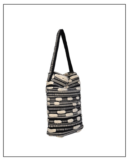 Side View of Antonello Tedde Bultei Tote Bag from the Trame in Fuga Collection, handwoven in Sardinia with black and natural cotton, textured woven motifs, and artisanal craftsmanship.