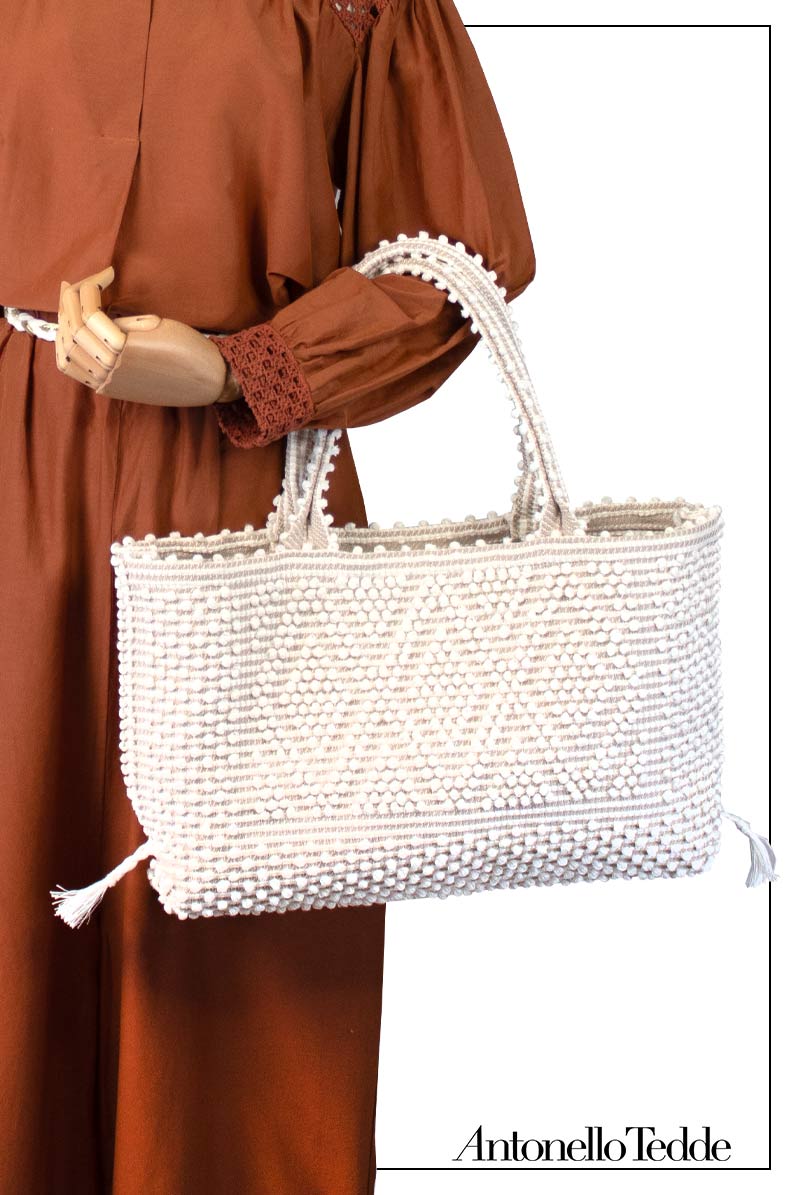 Mannequin holding a white handwoven handbag with 'Antonello Tedde' Medium tote bag cream base chestnut Ethical and Sustainable Handbags.  