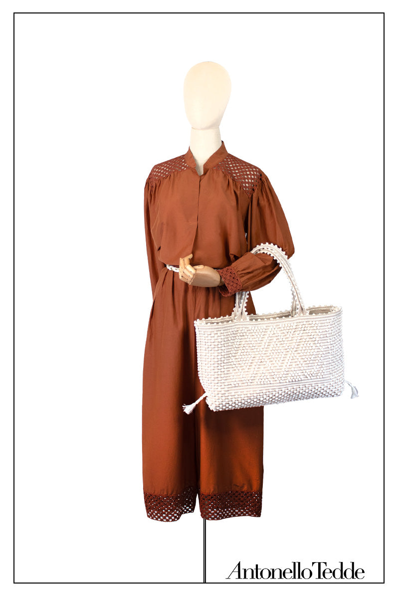 Mannequin wearing a brown outfit holding a white handwoven handbag with 'Antonello Tedde' branding. Medium tote bag cream base chestnut Ethical and Sustainable Handbags.  The best eco luxury bags and accessories brand. 