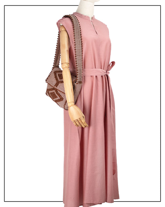 Pink dress on a mannequin with a matching chestnut handbag against a white background with a geometric pattern made in Italy by hand • timeless individualistic fashion • eco-friendly fashion • socially responsible, lasting fashion.