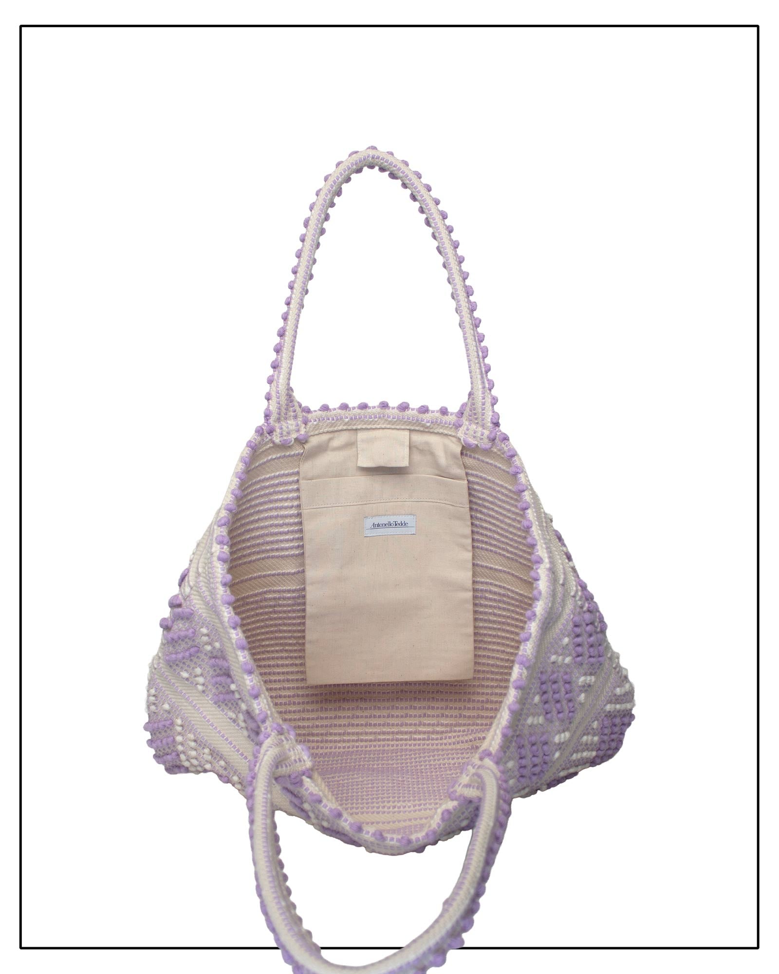 Antonello Tedde Mugoni Zig Zag Tote Bag, handwoven in Sardinia from linen and cotton with geometric zig zag weave and diamond motifs - Pocket view of tote bag with purple on a cream background