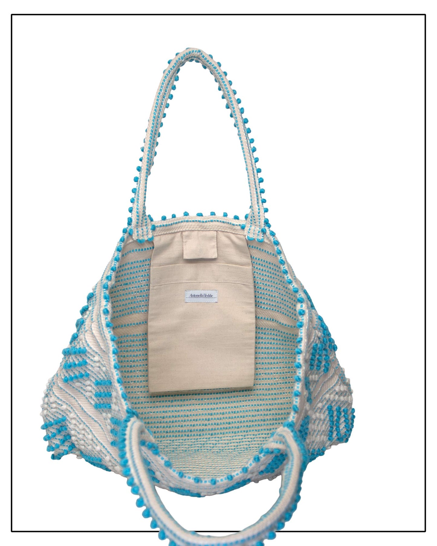 Antonello Tedde Mugoni Zig Zag Tote Bag, handwoven in Sardinia from linen and cotton with geometric zig zag weave and diamond motifs - Inside pocket view of tote bag with turquoise on a cream background