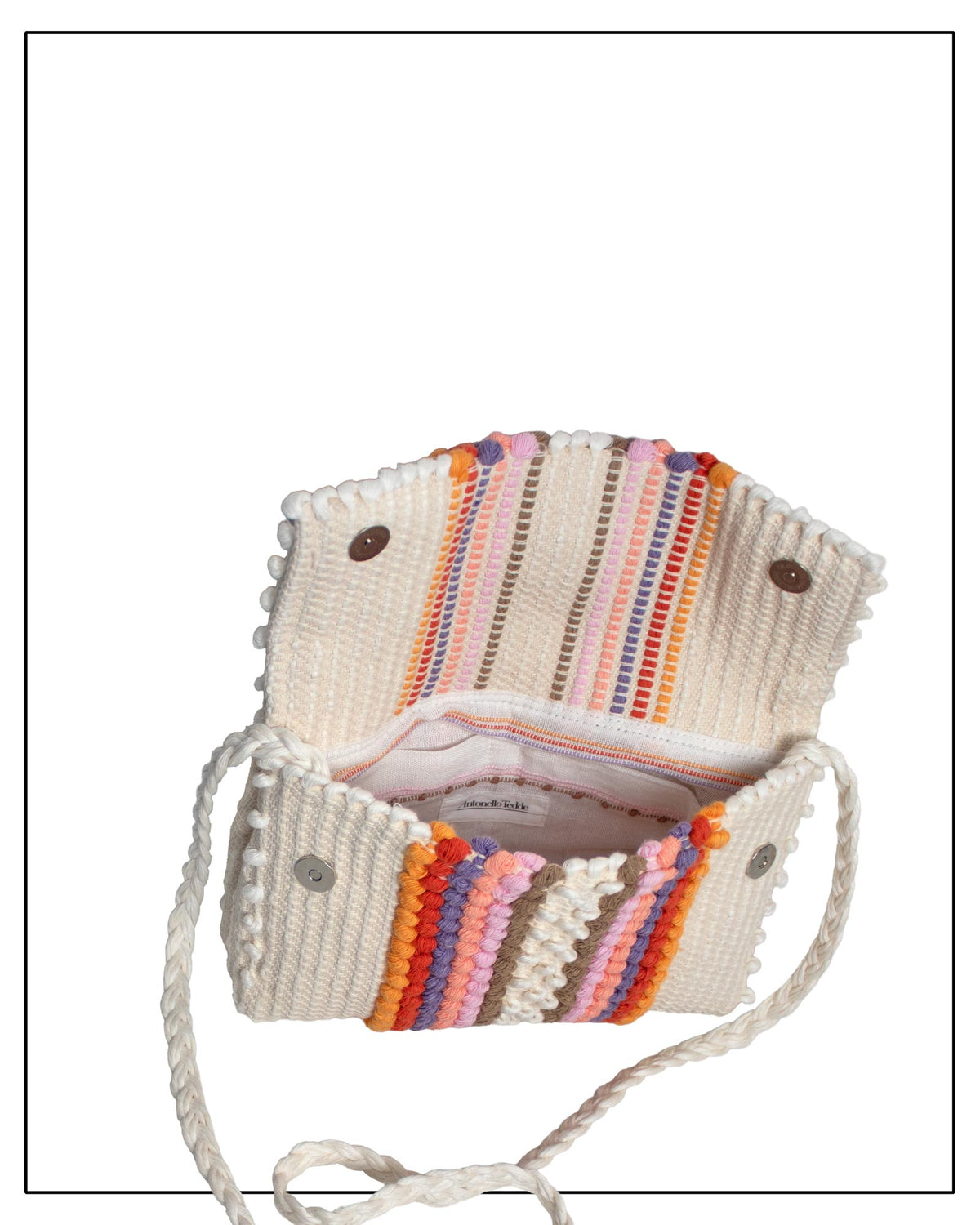 View of Antonello Tedde Suni Fire Lining and pocket view with branding of a crossbody bag handwoven in Sardinia in cream linen and cotton with colourful raised stripes and braided shoulder strap.