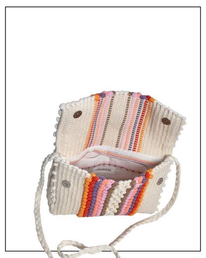 View of Antonello Tedde Suni Fire Lining and pocket view with branding of a crossbody bag handwoven in Sardinia in cream linen and cotton with colourful raised stripes and braided shoulder strap.