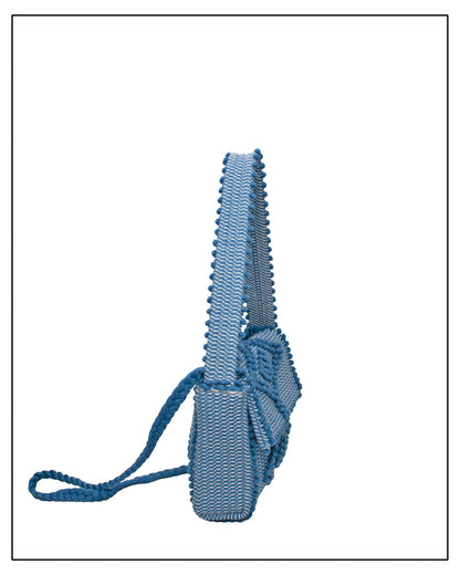 Side view of Antonello Tedde Suni X crossbody bag handwoven in Sardinia from denim blue, grey and cream cotton with raised rombi pattern and braided shoulder strap