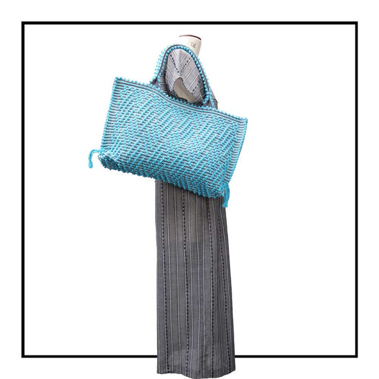 The handbag on a model - Sustainable tote - summer bag - luxury handbag - handwoven black and turquoise tote made in Italy by hand • timeless individualistic fashion • eco-friendly fashion • socially responsible, lasting fashion.