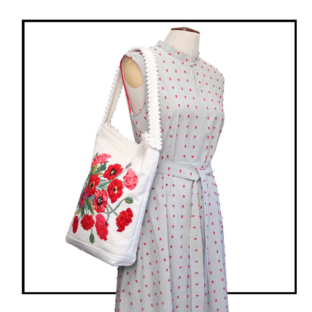 on stand with dress detail Bultei_bucket bag_red flowers with white ground Best eco luxury bags and accessories brand. Stylish clothes and Eco-Friendly with recycled yarns #luxury #ecoconcious #sustainablestyle #ethicalbrands #ecoliving #ecofashion #ecostyle #ethicalhandbags #handbags