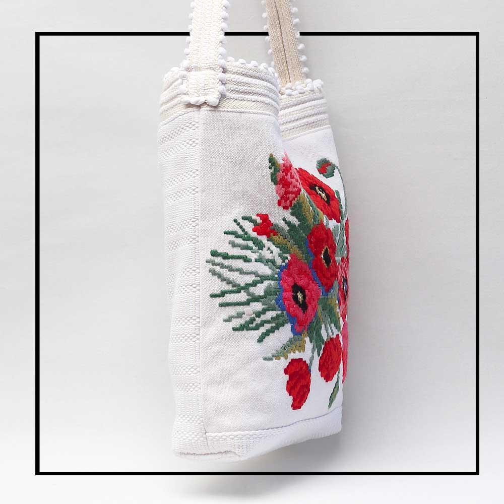 side view of  Bultei_bucket bag_red flowers with white ground Best eco luxury bags and accessories brand. Stylish clothes and Eco-Friendly with recycled yarns #luxury #ecoconcious #sustainablestyle #ethicalbrands #ecoliving #ecofashion #ecostyle #ethicalhandbags #handbags